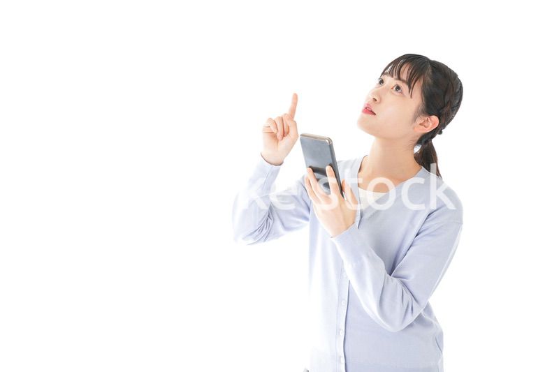 IOT家電をスマホで操作する若い女性