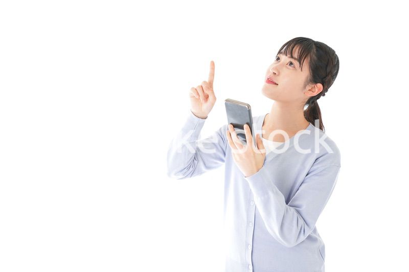 IOT家電をスマホで操作する若い女性