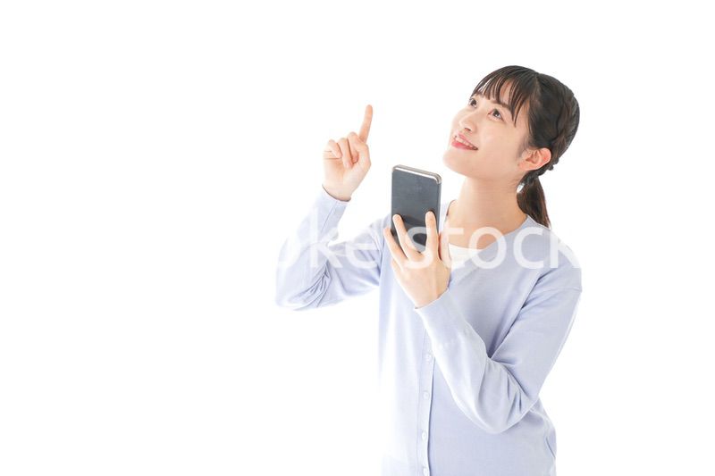 IOT家電をスマホで操作する若い女性