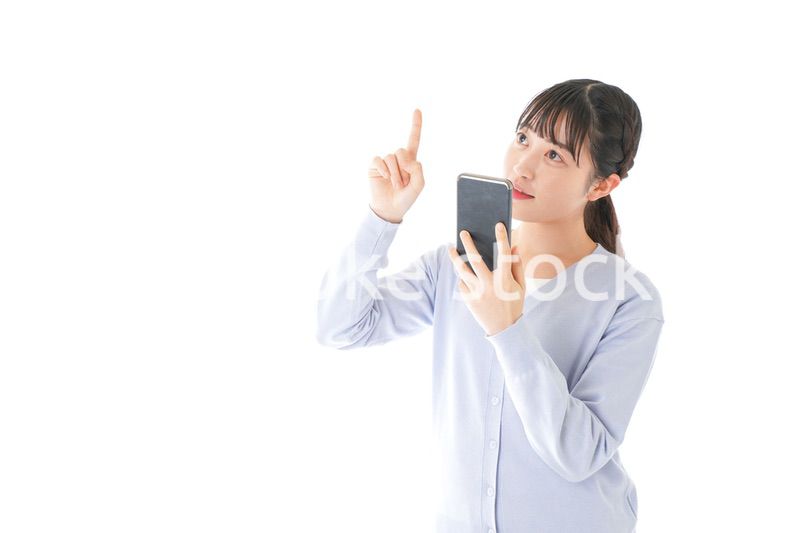 IOT家電をスマホで操作する若い女性