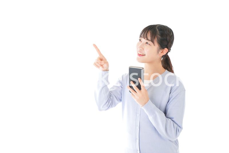 IOT家電をスマホで操作する若い女性