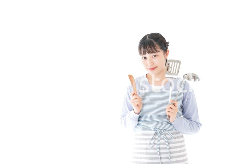 笑顔で料理をする若い主婦