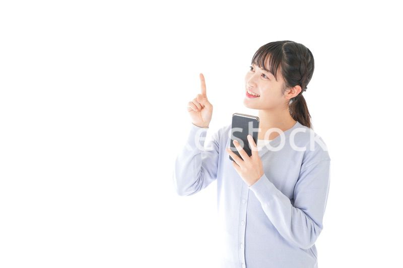 IOT家電をスマホで操作する若い女性