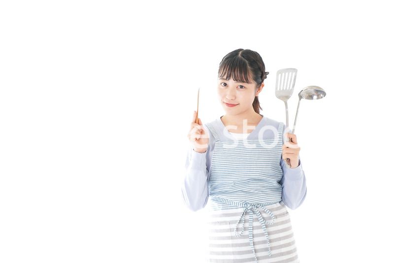 笑顔で料理をする若い主婦