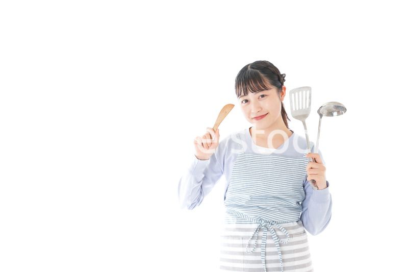 笑顔で料理をする若い主婦