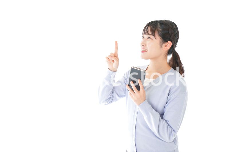 IOT家電をスマホで操作する若い女性