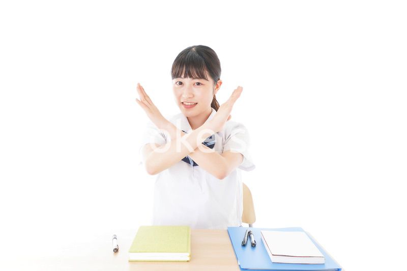 バツを示す制服姿の女子学生