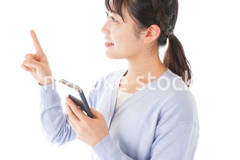 IOT家電をスマホで操作する若い女性