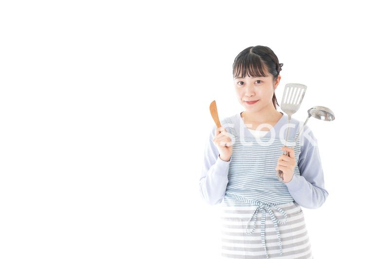 笑顔で料理をする若い主婦