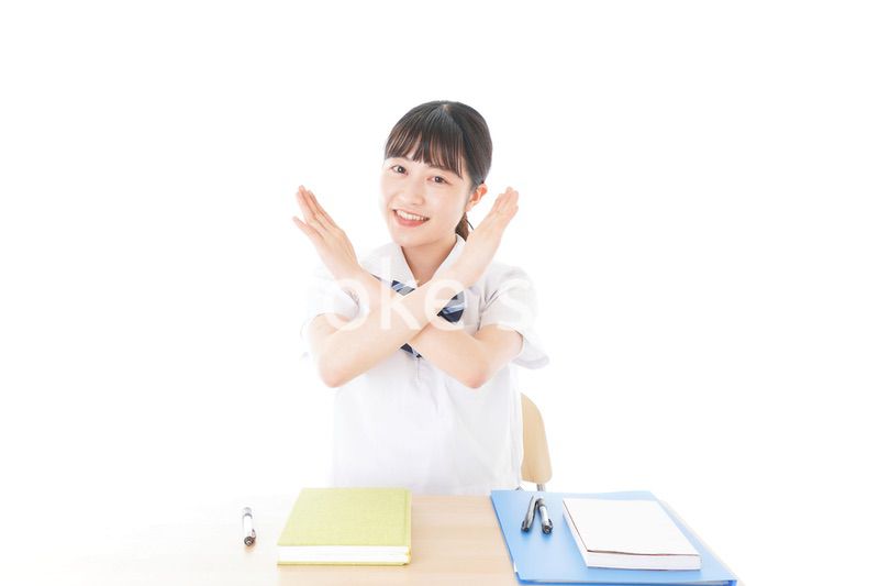 バツを示す制服姿の女子学生