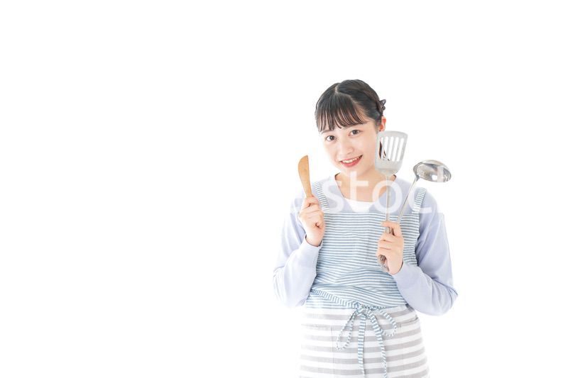 笑顔で料理をする若い主婦