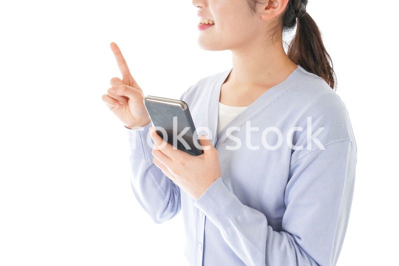 IOT家電をスマホで操作する若い女性