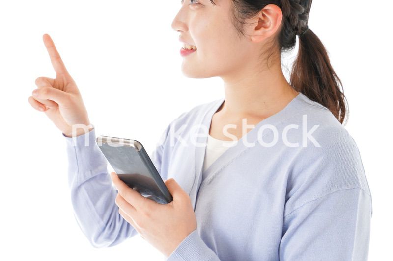 IOT家電をスマホで操作する若い女性