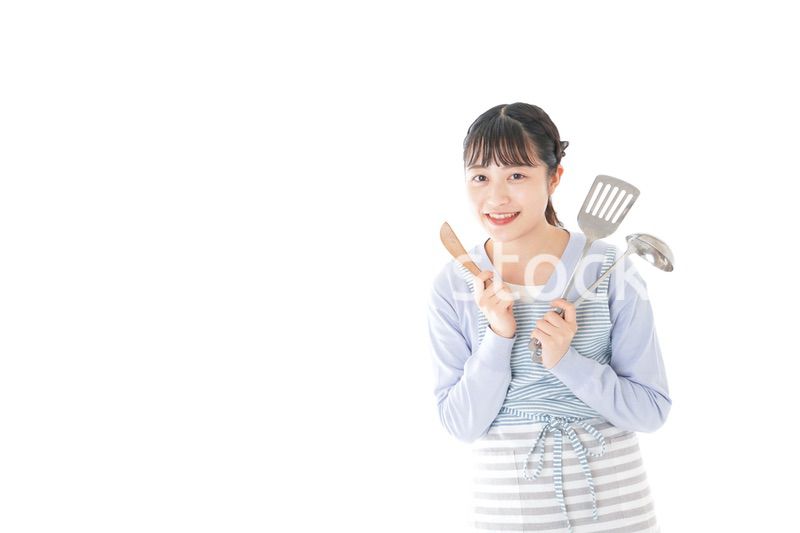 笑顔で料理をする若い主婦