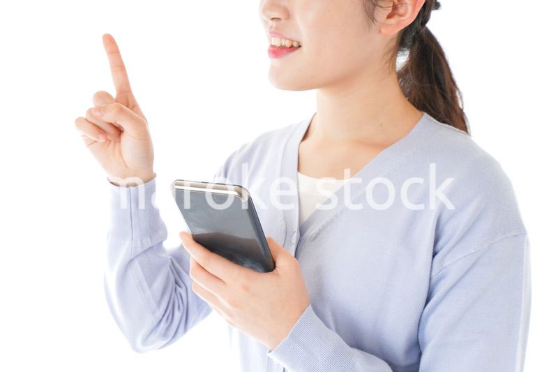 IOT家電をスマホで操作する若い女性