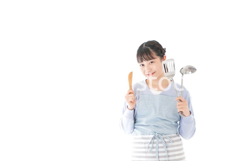 笑顔で料理をする若い主婦