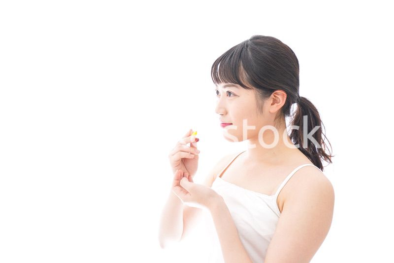 薬・サプリメントを飲む若い女性