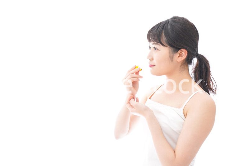 薬・サプリメントを飲む若い女性