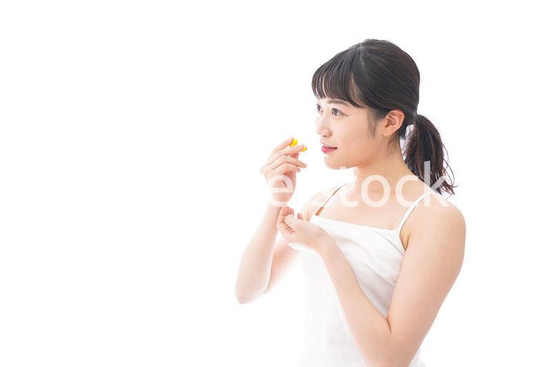 薬・サプリメントを飲む若い女性