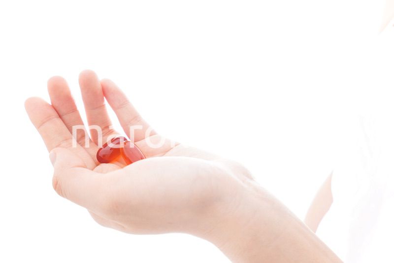 薬・サプリメントを飲む若い女性