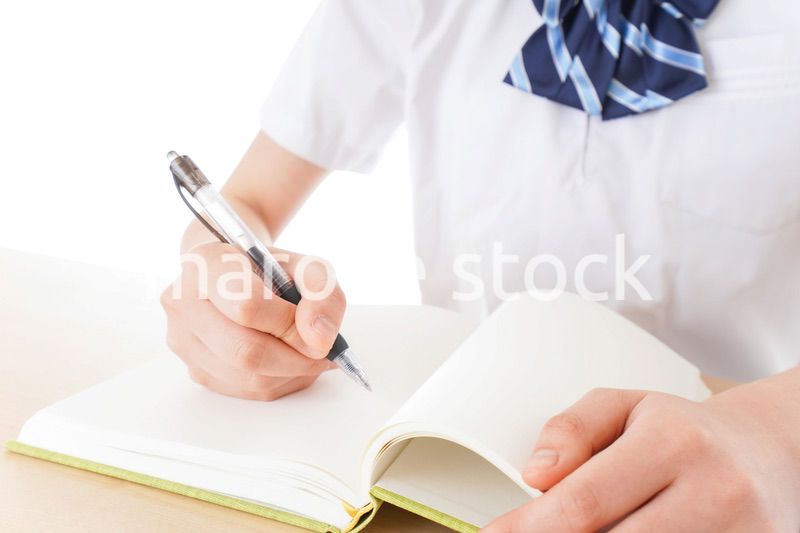 机で勉強をする制服姿の女子学生