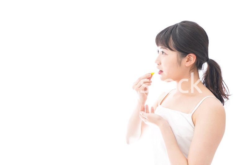 薬・サプリメントを飲む若い女性