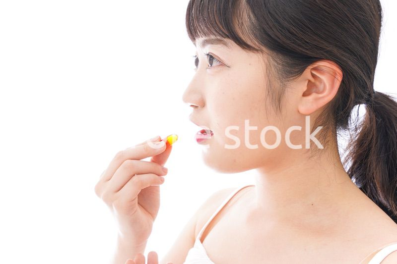 薬・サプリメントを飲む若い女性