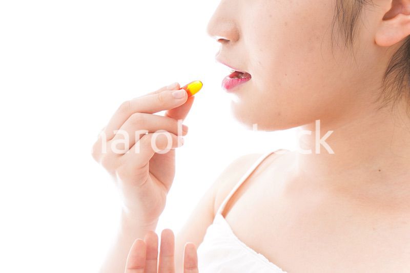 薬・サプリメントを飲む若い女性