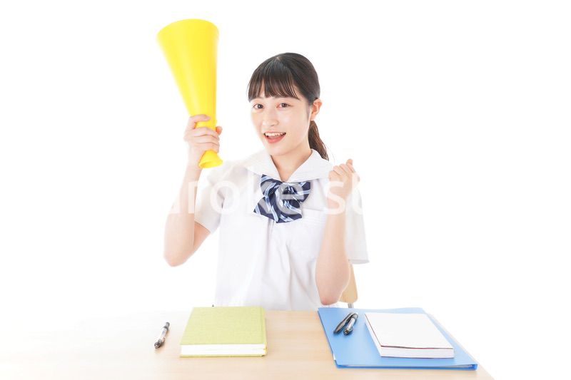 応援をする制服姿の女子学生