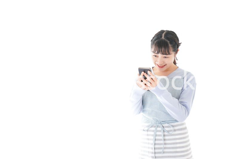 笑顔でスマートフォンを使う若い主婦