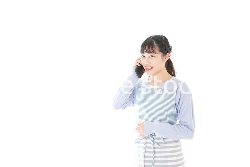 笑顔でスマートフォンを使う若い主婦