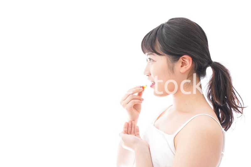 薬・サプリメントを飲む若い女性