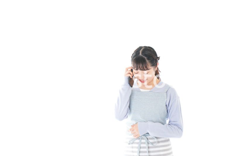 笑顔でスマートフォンを使う若い主婦