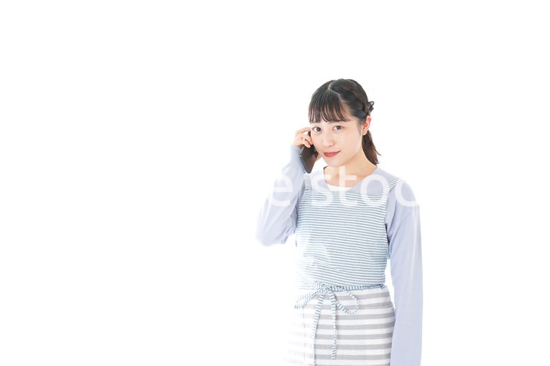 笑顔でスマートフォンを使う若い主婦