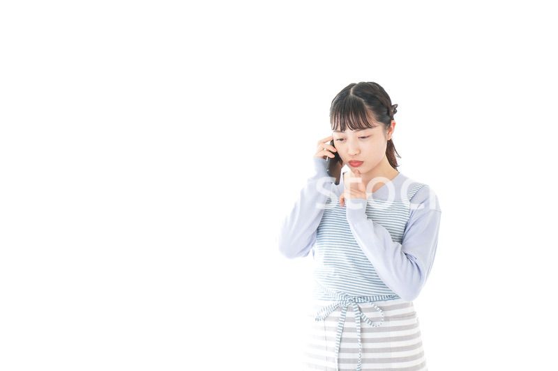 笑顔でスマートフォンを使う若い主婦