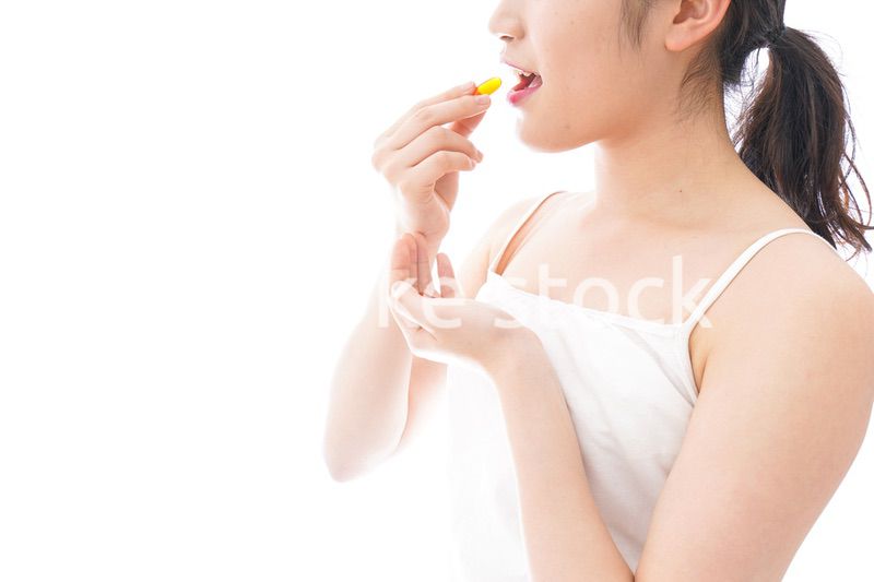 薬・サプリメントを飲む若い女性