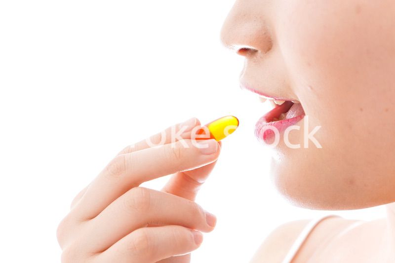 薬・サプリメントを飲む若い女性