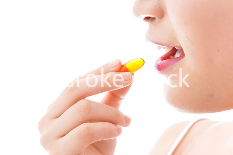 薬・サプリメントを飲む若い女性