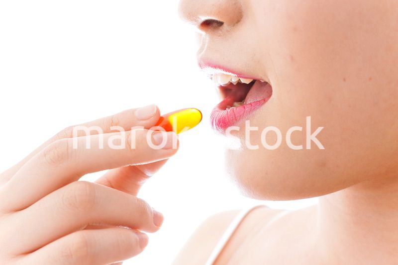 薬・サプリメントを飲む若い女性