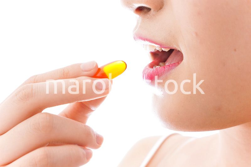 薬・サプリメントを飲む若い女性