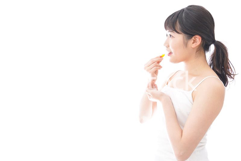 薬・サプリメントを飲む若い女性