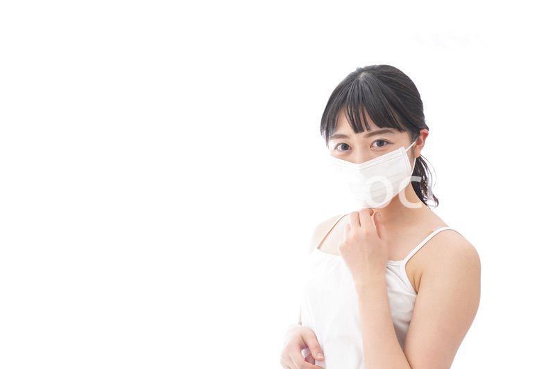 花粉症・風邪・インフルエンザに苦しみマスクをする若い女性