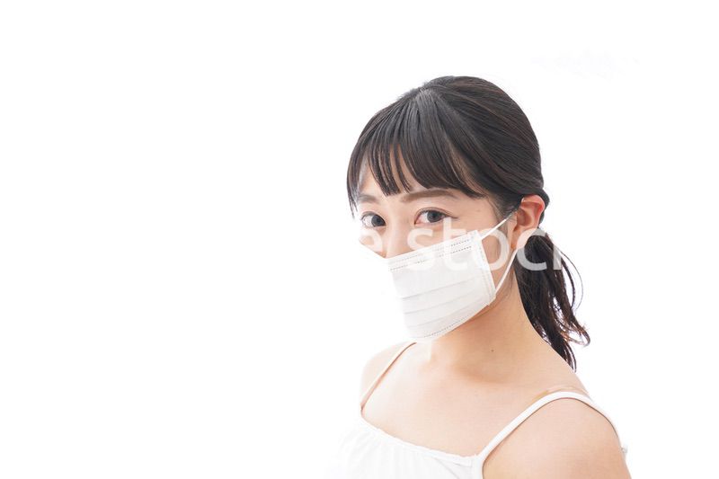 花粉症・風邪・インフルエンザに苦しみマスクをする若い女性