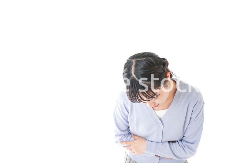 腹痛に苦しむ若い女性