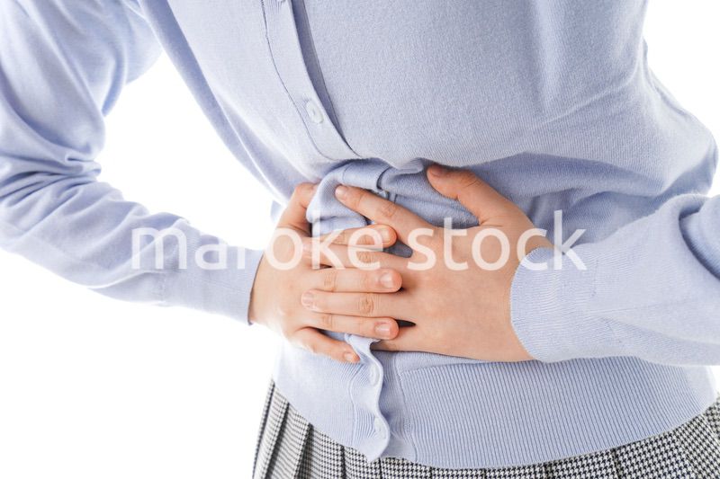 腹痛に苦しむ若い女性