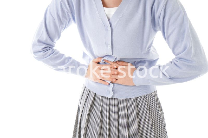 腹痛に苦しむ若い女性