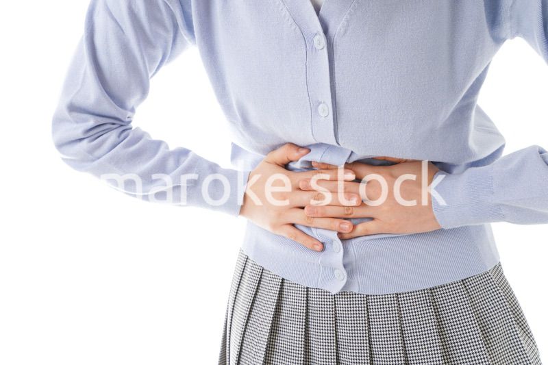 腹痛に苦しむ若い女性