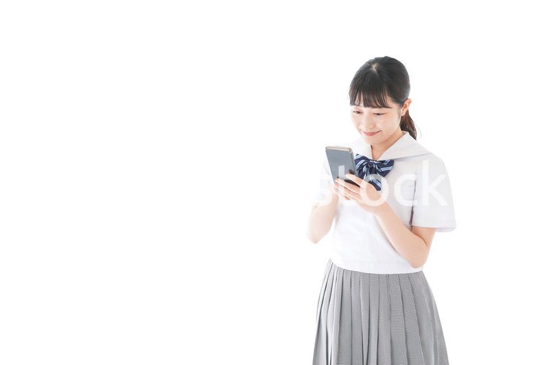 スマホを使う制服姿の女子学生