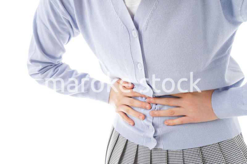 腹痛に苦しむ若い女性