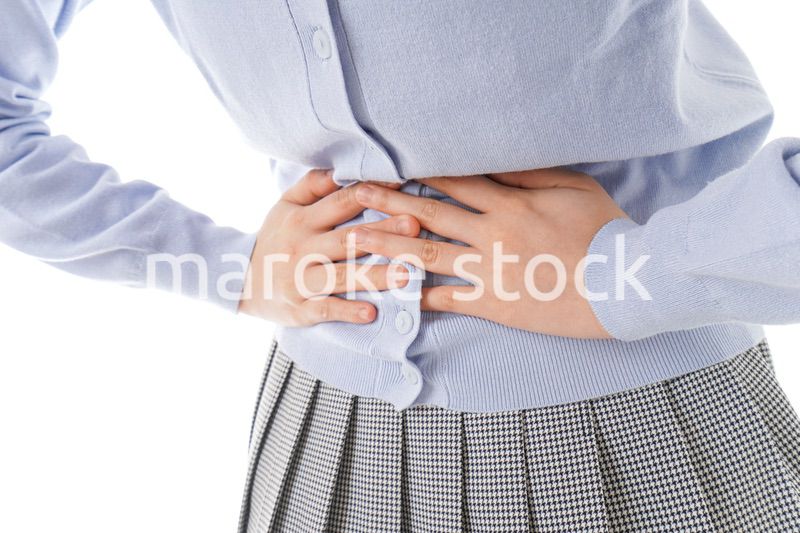 腹痛に苦しむ若い女性